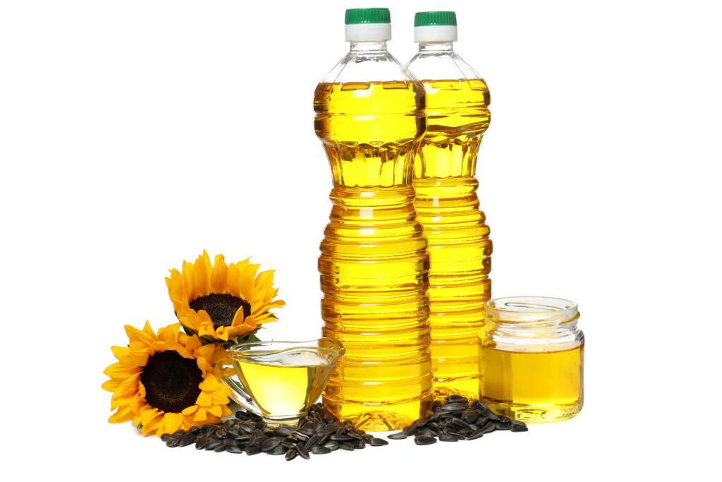 Oil in jars and bottles, seeds and sunflowers, isolated on white background