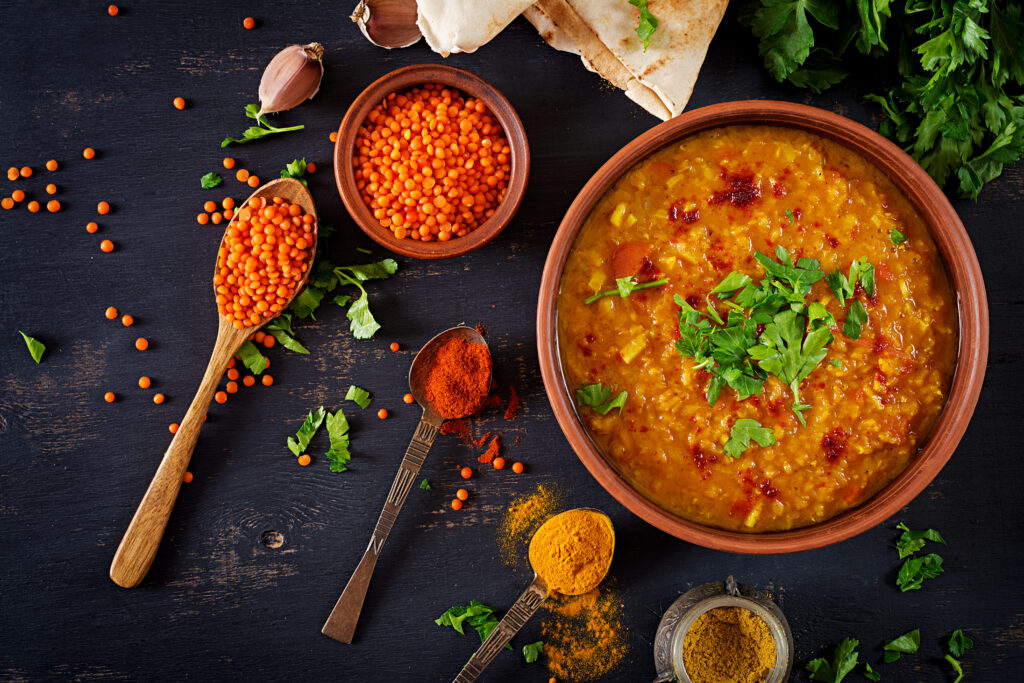 traditional-indian-soup-lentils-indian-dhal-spicy-curry-bowl-spices-chana masla-rustic-black-wooden-table